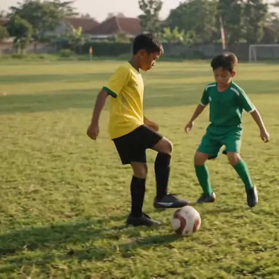 Pemain muda melindungi bola dari lawan